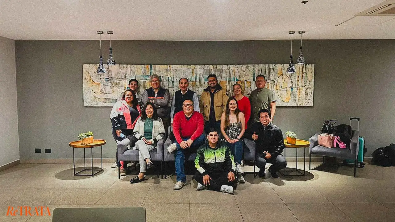 Foto grupal a color de los asistentes del curso de fotografía RETRATA en Puebla, Agosto 2023, posando en un interior moderno.