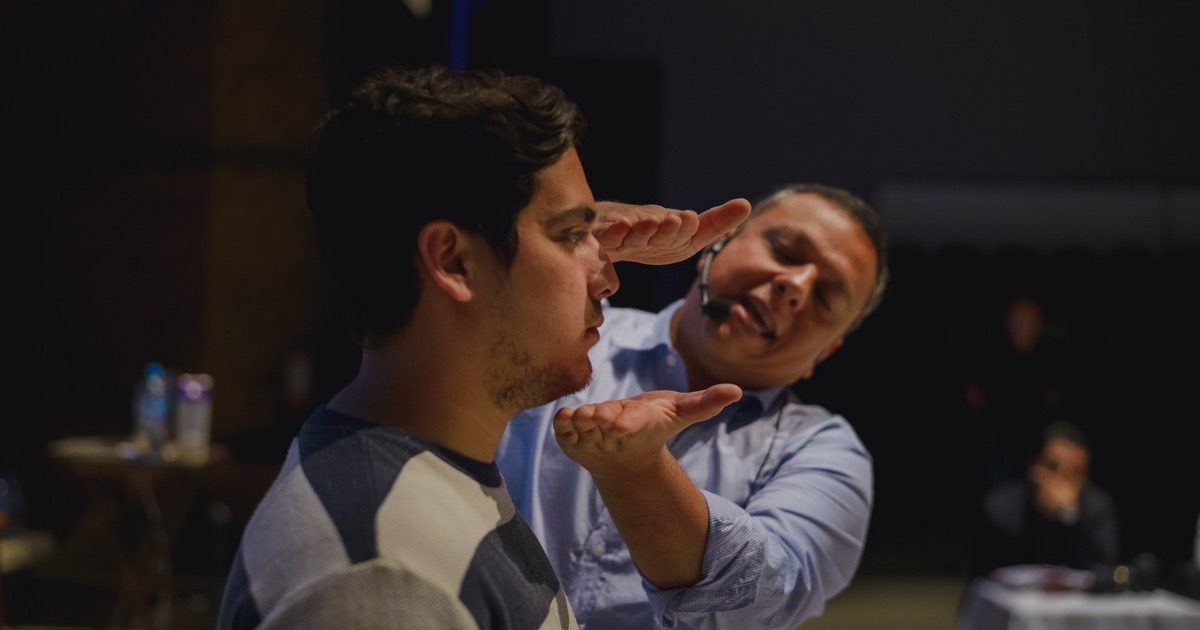 Raúl Galavíz corrige el encuadre de un fotógrafo con las manos durante un taller RETRATA