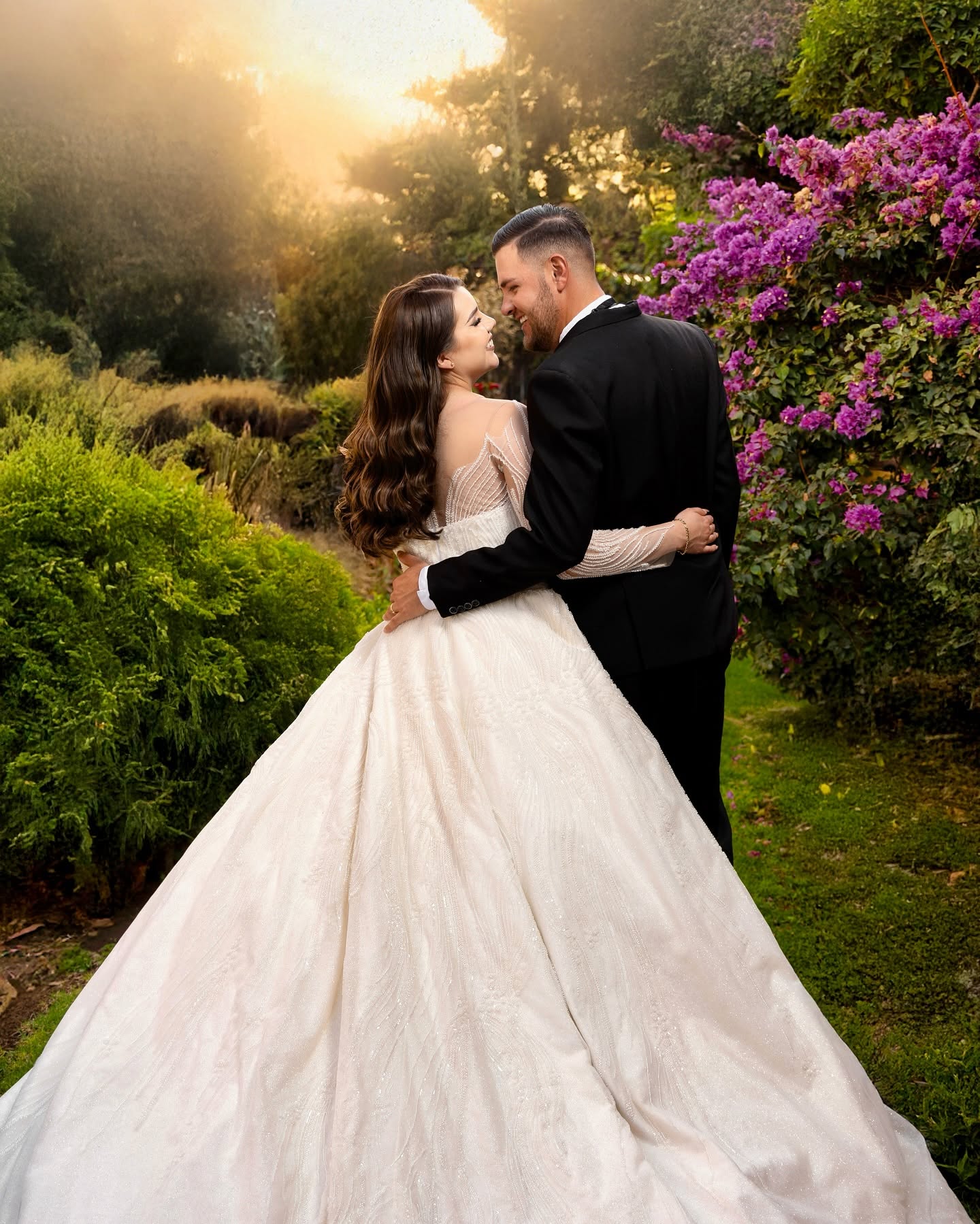 Novios abrazados en un jardín con bugambilias, fotografía de RocyMartin